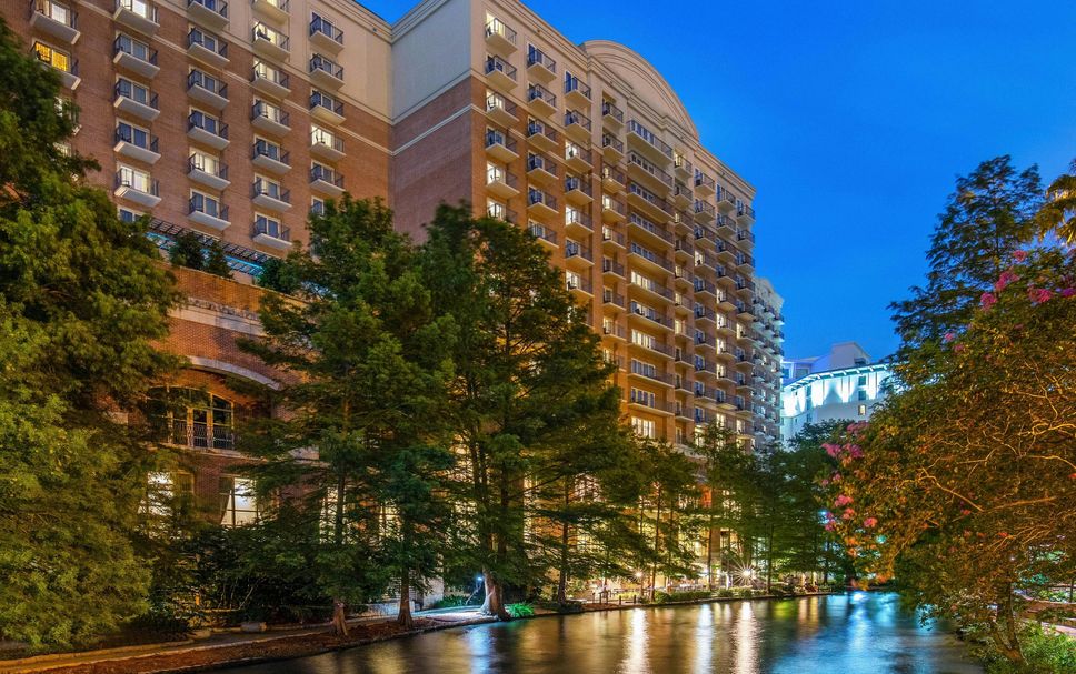 The Westin Riverwalk San Antonio riverfront exterior at blue hour